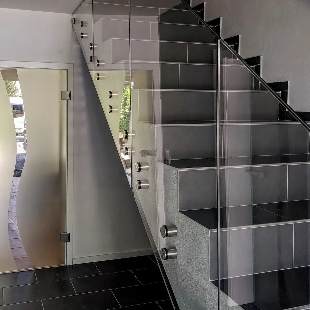Treppengeländer aus Klarglas mit Punkthaltern an einer Treppe im Haus