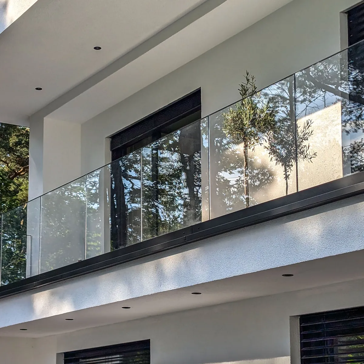 Ganzglasgeländer an einem modernen Haus, Glas als Balkongeländer im Obergeschoss